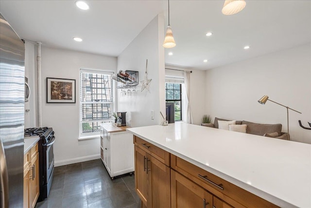 30-69 Hobart St Unit 2P, Woodside, NY 11377 - kitchen with stainless steel range with gas stovetop, light countertops, recessed lighting, brown cabinets, and hanging light fixtures
