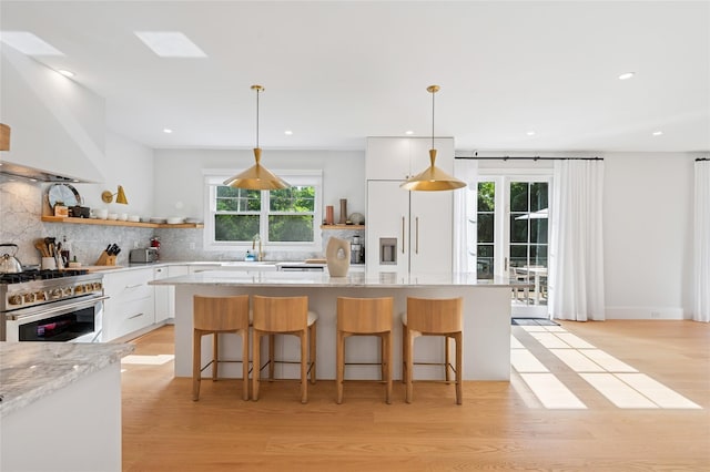 5 Kings Ln, Southampton, NY 11968 - kitchen featuring high end range, white cabinetry, light wood-style floors, open shelves, and tasteful backsplash