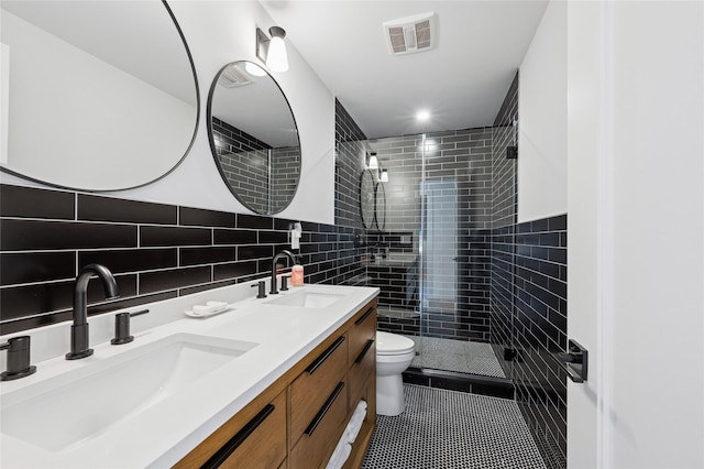 5 Kings Ln, Southampton, NY 11968 - bathroom featuring double vanity, tile walls, tiled shower, and tile patterned floors