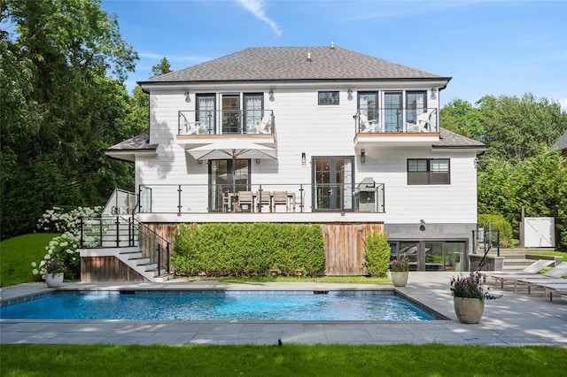 5 Kings Ln, Southampton, NY 11968 - rear view of property with stairway, a balcony, an outdoor pool, a shingled roof, and a patio