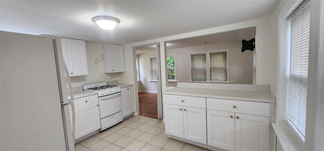 344 Elm Rd W, Mastic Beach, NY 11951 - kitchen featuring white appliances, light tile patterned floors, light countertops, and white cabinetry