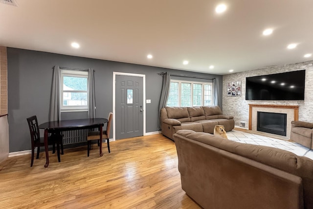 61 Ulster Ave, West Babylon, NY 11704 - living room with healthy amount of natural light, light wood-style flooring, a fireplace, and recessed lighting