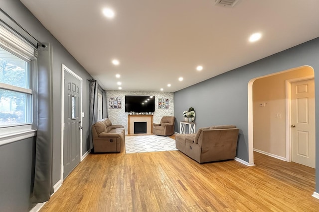 61 Ulster Ave, West Babylon, NY 11704 - living room with light wood-type flooring, arched walkways, recessed lighting, and a fireplace
