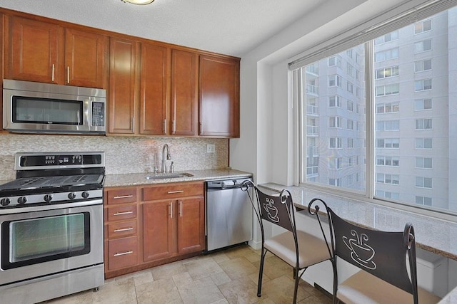 3333 Henry Hudson Pkwy W Unit 4M, Bronx, NY 10463 - kitchen with stainless steel appliances, tasteful backsplash, brown cabinetry, light stone countertops, and stone finish floors