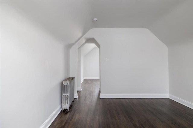22324 Murdock Ave, Queens Village, NY 11429 - additional living space with radiator, lofted ceiling, wood finished floors, and arched walkways