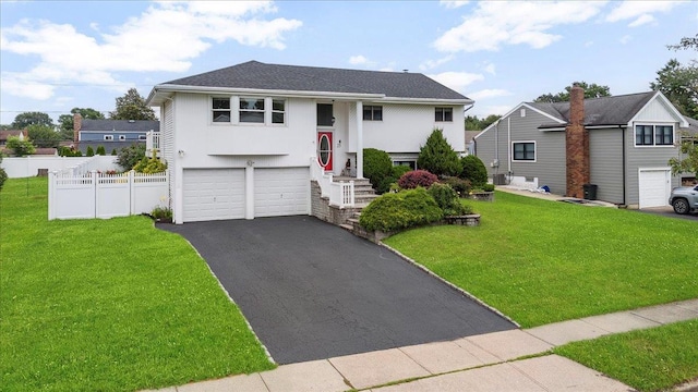 25 Amapola Ln, Kings Park, NY 11754 - raised ranch with asphalt driveway, a garage, and stucco siding
