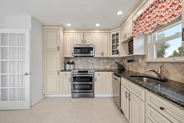 25 Amapola Ln, Kings Park, NY 11754 - kitchen with stainless steel appliances, cream cabinets, dark stone countertops, backsplash, and light tile patterned floors