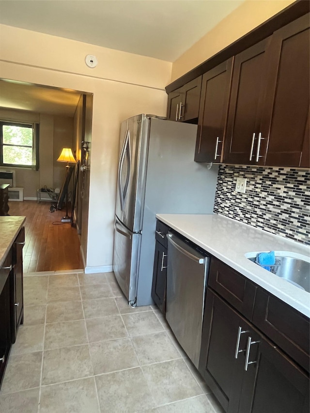 90-32 153rd Ave Unit 0029, Howard Beach, NY 11414 - kitchen with appliances with stainless steel finishes, light countertops, dark brown cabinets, and tasteful backsplash