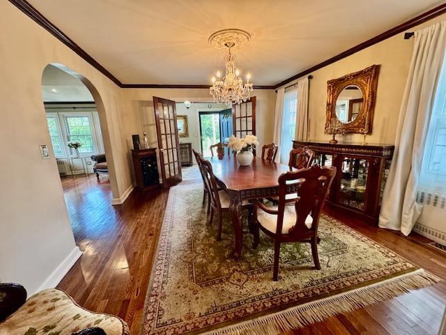 987 E Prospect St, Woodmere, NY 11598 - dining area featuring ornamental molding, wood finished floors, arched walkways, and a chandelier