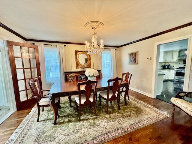 987 E Prospect St, Woodmere, NY 11598 - dining space featuring a chandelier, ornamental molding, dark wood finished floors, and plenty of natural light