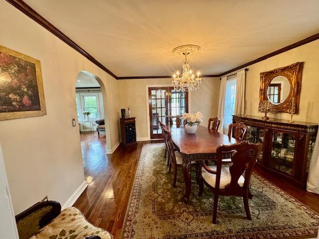 987 E Prospect St, Woodmere, NY 11598 - dining space with a chandelier, dark wood finished floors, ornamental molding, and arched walkways