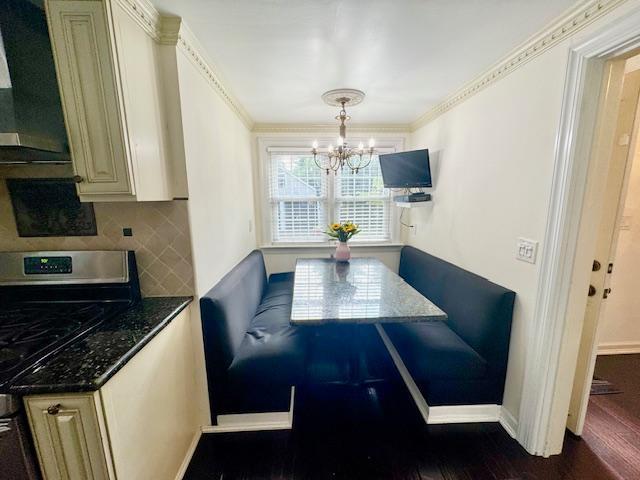 987 E Prospect St, Woodmere, NY 11598 - dining area with a chandelier, dark wood-type flooring, and crown molding
