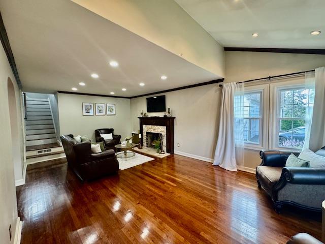 987 E Prospect St, Woodmere, NY 11598 - living area featuring stairway, crown molding, a fireplace, vaulted ceiling, and wood finished floors