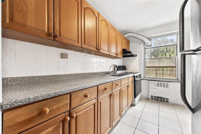 147-25 38th Ave Unit F26, Flushing, NY 11354 - kitchen with freestanding refrigerator, under cabinet range hood, white gas stove, brown cabinets, and tasteful backsplash