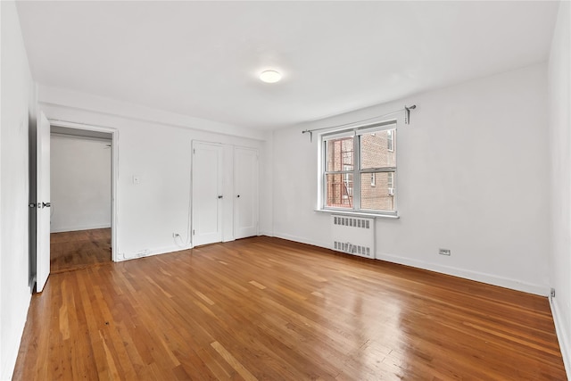147-25 38th Ave Unit F26, Flushing, NY 11354 - unfurnished bedroom with radiator heating unit and hardwood / wood-style flooring