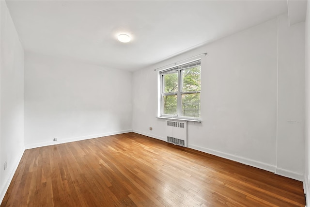 147-25 38th Ave Unit F26, Flushing, NY 11354 - unfurnished room featuring radiator heating unit and hardwood / wood-style flooring