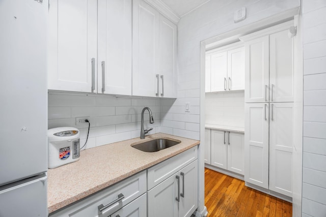 142-05 Roosevelt Ave Unit 627, Flushing, NY 11354 - kitchen featuring freestanding refrigerator, crown molding, decorative backsplash, wood finished floors, and white cabinets