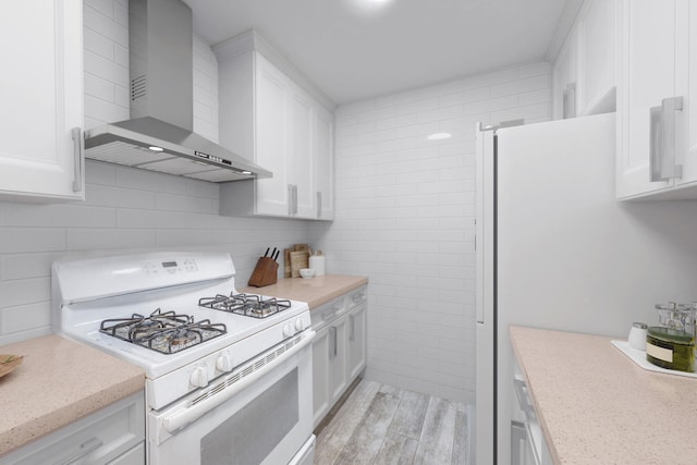 142-05 Roosevelt Ave Unit 627, Flushing, NY 11354 - kitchen featuring white appliances, wall chimney range hood, white cabinetry, decorative backsplash, and light wood-type flooring