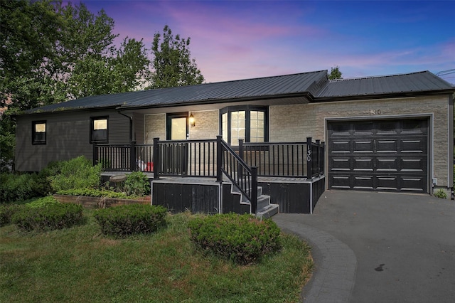 130 Marcus Rd, Ellenville, NY 12428 - ranch-style house featuring a garage, covered porch, a metal roof, and asphalt driveway