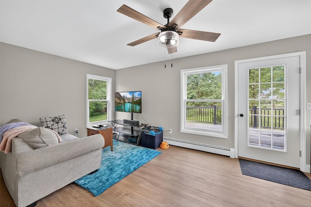 130 Marcus Rd, Ellenville, NY 12428 - living room with a baseboard radiator, wood finished floors, a ceiling fan, and healthy amount of natural light