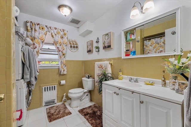 227 Randall Ave, Lawrence, NY 11559 - full bathroom with stacked washer / dryer, radiator, vanity, tile patterned flooring, and tile walls