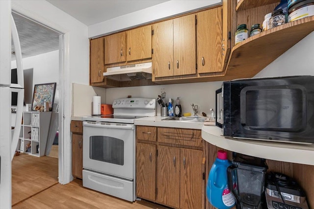 227 Randall Ave, Lawrence, NY 11559 - kitchen featuring white appliances, light countertops, light wood-type flooring, under cabinet range hood, and brown cabinets