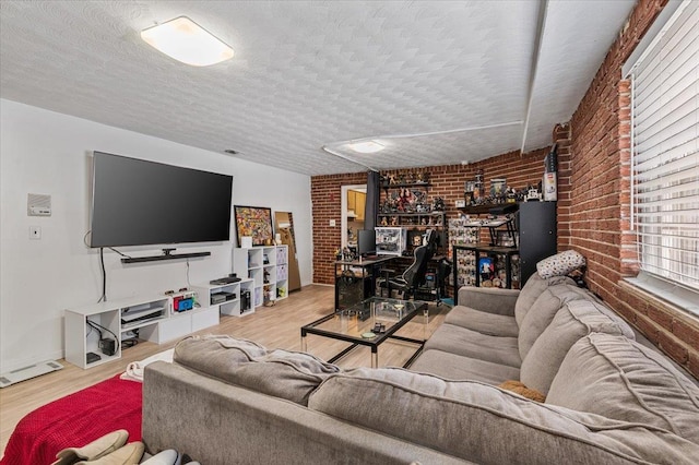 227 Randall Ave, Lawrence, NY 11559 - living area with brick wall, wood finished floors, and a textured ceiling