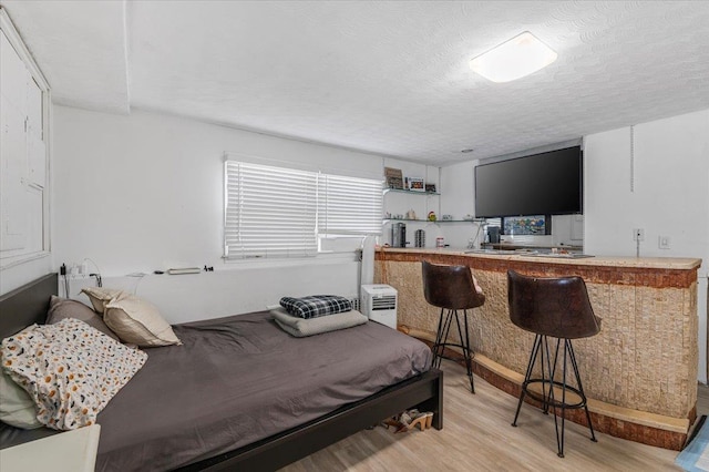 227 Randall Ave, Lawrence, NY 11559 - bedroom featuring light wood finished floors, a textured ceiling, and bar
