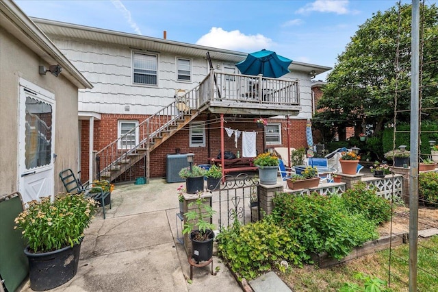 227 Randall Ave, Lawrence, NY 11559 - rear view of property with stairs, brick siding, a patio, and a deck