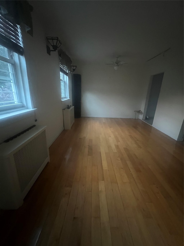 264-31 Langston Ave Fl 2Nd, Glen Oaks, NY 11004 - unfurnished room with radiator heating unit, wood-type flooring, and a ceiling fan