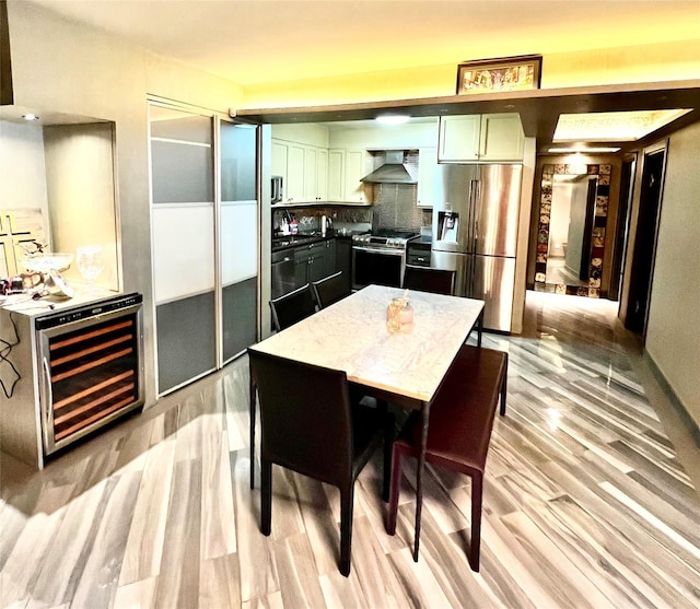 21019 26th Avenue Tl, Bayside, NY 11360 - kitchen with appliances with stainless steel finishes, beverage cooler, wall chimney exhaust hood, and light wood-style flooring