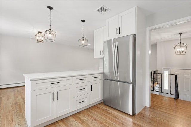 297 Farm To Market Rd, Brewster, NY 10509 - kitchen featuring freestanding refrigerator, a chandelier, a peninsula, and white cabinetry