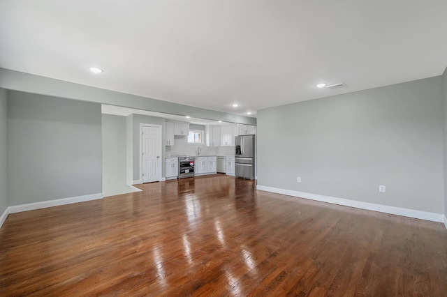 248 E Shore Rd, Lindenhurst, NY 11757 - unfurnished living room featuring dark wood-style floors and recessed lighting