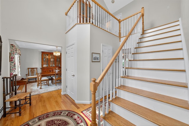 106 Maple Ave, Goshen, NY 10924 - staircase with a high ceiling, wood finished floors, a chandelier, and a baseboard radiator