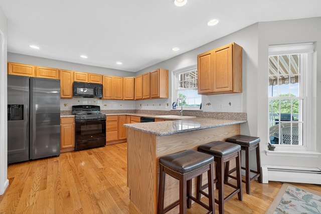 106 Maple Ave, Goshen, NY 10924 - kitchen featuring black appliances, light wood-type flooring, plenty of natural light, a baseboard radiator, and recessed lighting