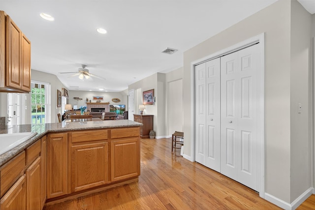 106 Maple Ave, Goshen, NY 10924 - kitchen with ceiling fan, a tile fireplace, light wood finished floors, a peninsula, and open floor plan
