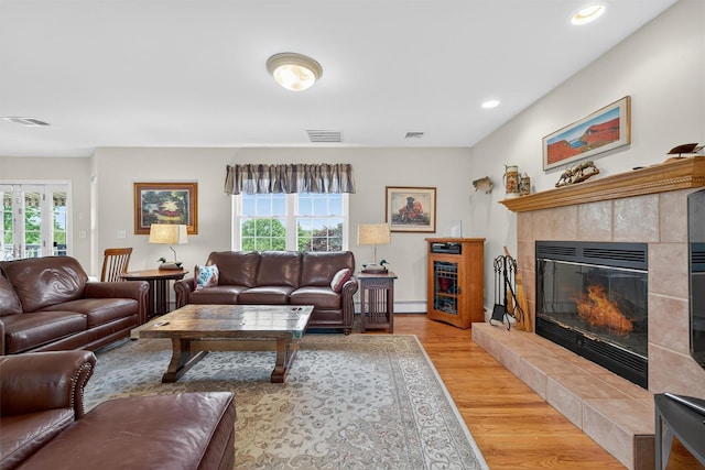 106 Maple Ave, Goshen, NY 10924 - living area with healthy amount of natural light, light wood-type flooring, a tiled fireplace, a baseboard radiator, and recessed lighting