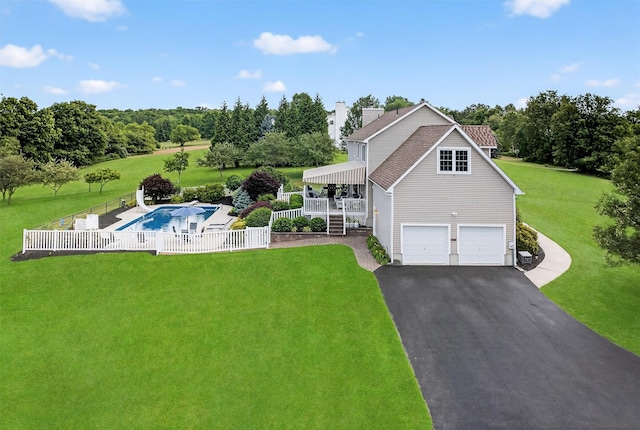106 Maple Ave, Goshen, NY 10924 - view of front facade with a garage, asphalt driveway, an outdoor pool, a chimney, and view of scattered trees