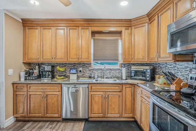 511 N Delaware Ave, Lindenhurst, NY 11757 - kitchen with stainless steel appliances, tasteful backsplash, brown cabinetry, and light stone countertops