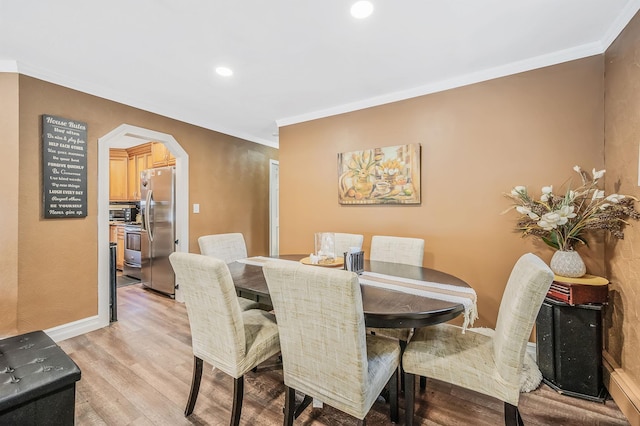 511 N Delaware Ave, Lindenhurst, NY 11757 - dining space with arched walkways, ornamental molding, light wood-style flooring, and recessed lighting
