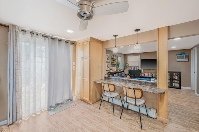 511 N Delaware Ave, Lindenhurst, NY 11757 - kitchen with light wood-type flooring, a baseboard heating unit, ceiling fan, a breakfast bar area, and a wall unit AC