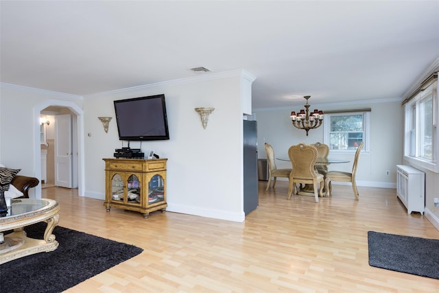 414 Pecan St, Lindenhurst, NY 11757 - living area with radiator heating unit, light wood-style floors, a chandelier, arched walkways, and ornamental molding