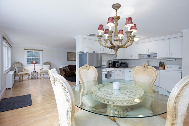 414 Pecan St, Lindenhurst, NY 11757 - dining area with a chandelier, light wood-style flooring, crown molding, and washer and clothes dryer