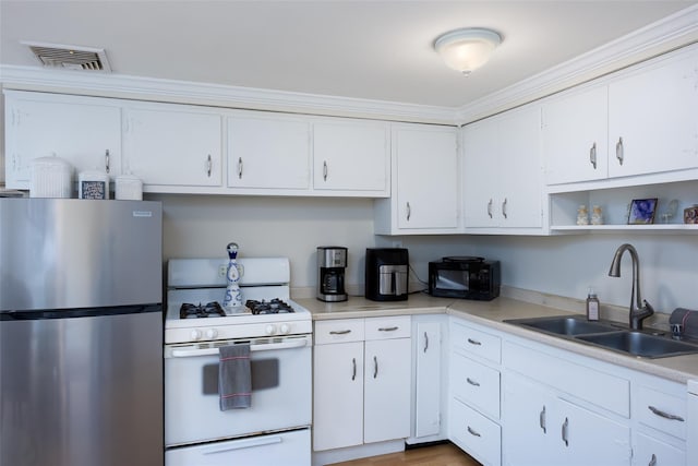 414 Pecan St, Lindenhurst, NY 11757 - kitchen with freestanding refrigerator, white range with gas cooktop, light countertops, white cabinetry, and open shelves