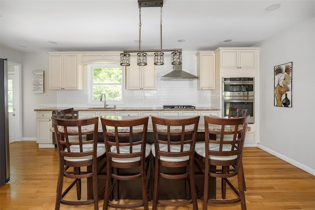18 Alexander Blvd, Poughkeepsie, NY 12603 - kitchen featuring appliances with stainless steel finishes, tasteful backsplash, wall chimney range hood, and light wood-type flooring