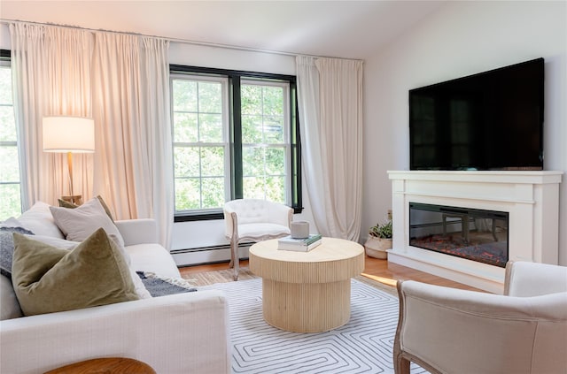 27 Maple Rd, Lake Peekskill, NY 10537 - living area with a glass covered fireplace, light wood finished floors, baseboard heating, and lofted ceiling