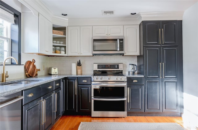 27 Maple Rd, Lake Peekskill, NY 10537 - kitchen with appliances with stainless steel finishes, white cabinetry, light stone counters, and tasteful backsplash