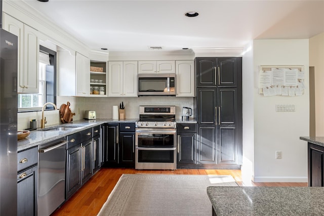 27 Maple Rd, Lake Peekskill, NY 10537 - kitchen with appliances with stainless steel finishes, white cabinets, light stone countertops, tasteful backsplash, and light wood-type flooring