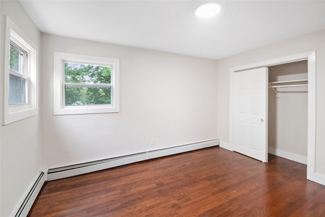 4 S Cardinal Ct, Islip, NY 11706 - unfurnished bedroom with a baseboard heating unit, dark wood-type flooring, and a closet