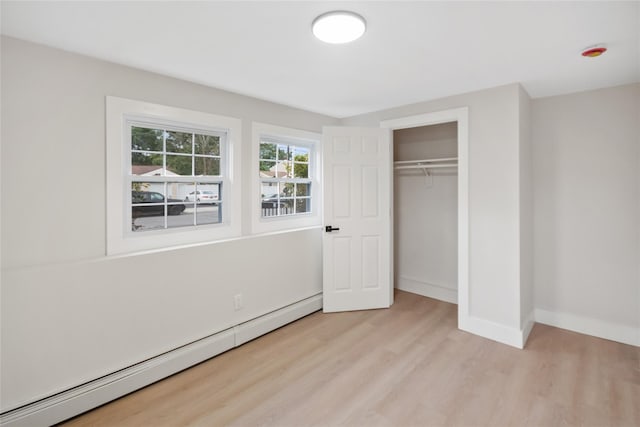 4 S Cardinal Ct, Islip, NY 11706 - unfurnished bedroom featuring baseboard heating, light wood finished floors, and a closet